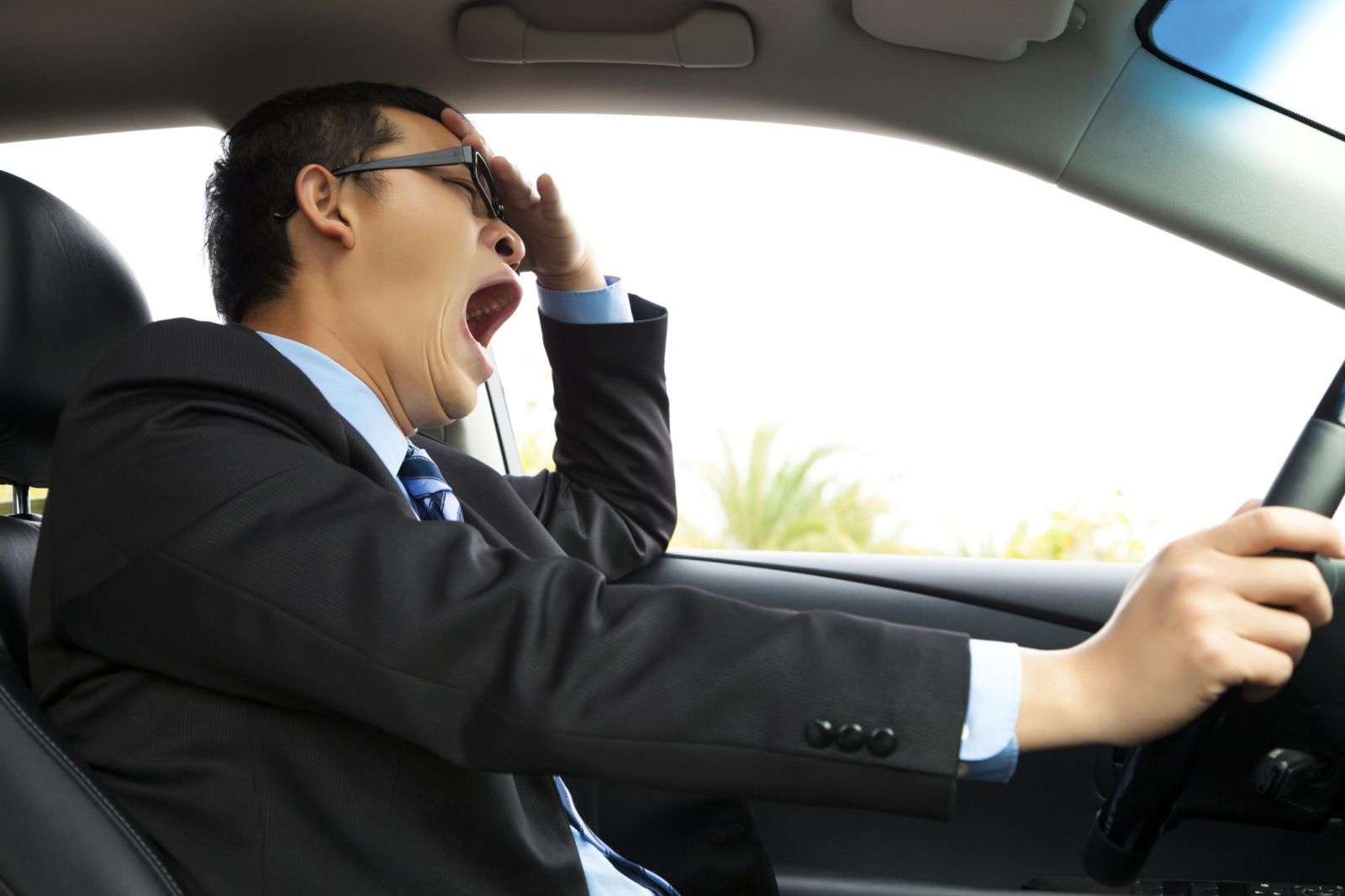 man driving while yawning